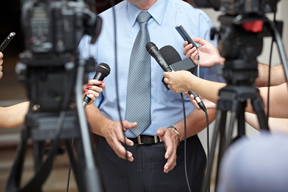 person standing in front of microphones