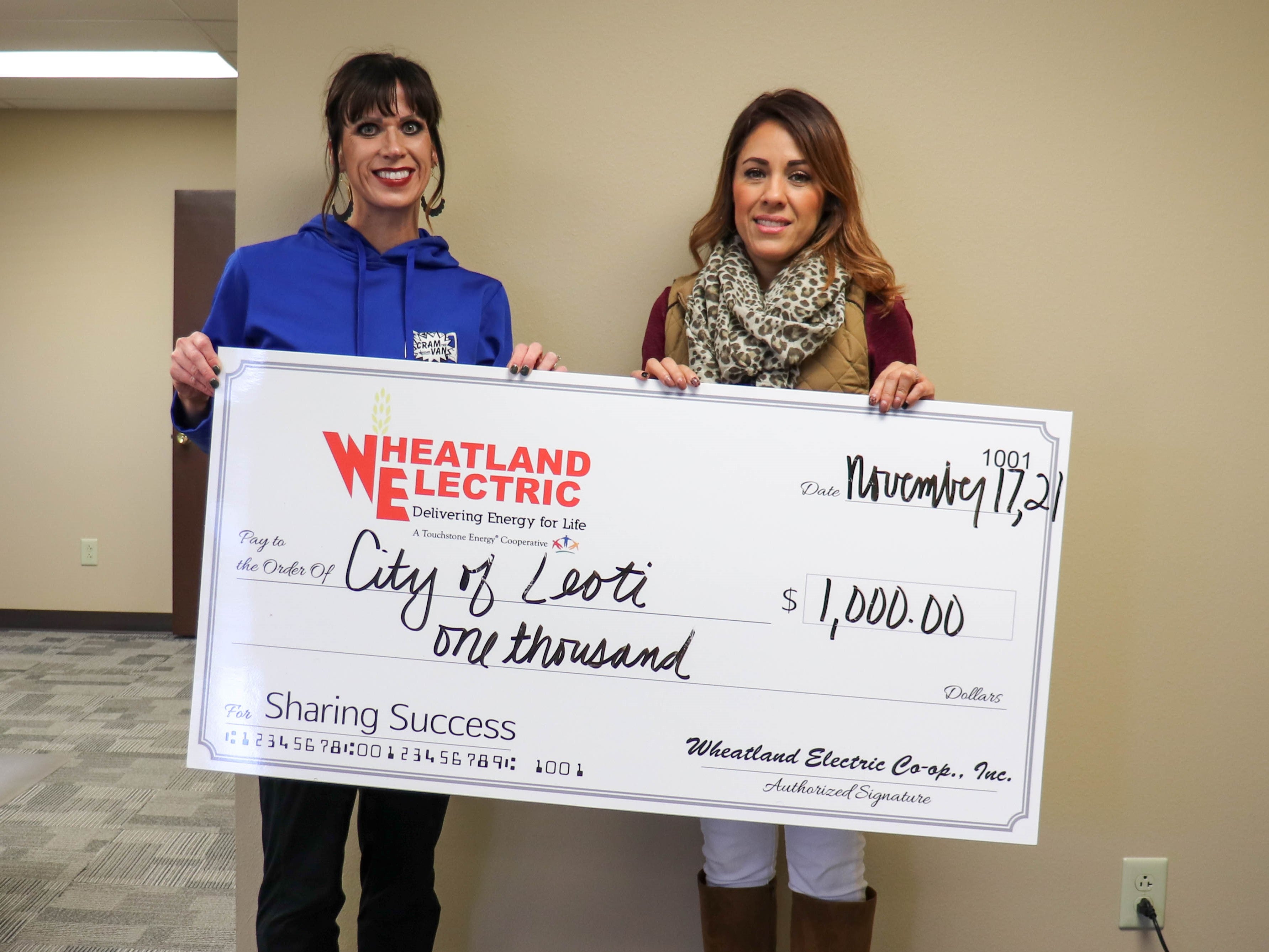 Alli Conine (left), manager of member services and corporate communications at Wheatland Electric, presents a $1,000 Sharing Success grant to Cindy Morcillo, deputy city clerk, to help install additional Christmas lights in downtown Leoti this holiday season. 